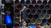 Para pekerja menyelesaikan pembuatan tempat sampah.