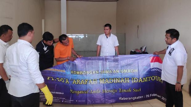 Polisi mengamankan spanduk PT Damtour di kantor tersebut.