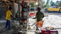 Pekerja memasukan bahan pembuat batako sebelum akhirnya di pres dan menjadi batako siap.