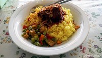 Dalam satu piring nasi kuning Banjar ini ada sayur kacang panjang dan kentang, mie kuning serta bawang goreng. Untuk lauknya, ada ikan tongkol dengan sambal yang cukup pedas. (Wahyu Setyo/detikcom)