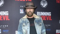 Dalam acara film Running With The Devil, Nicolas Cage tampil berbeda dengan topi cowboy, jaket jeans dan celana hitam. Jon Kopaloff/Getty Images