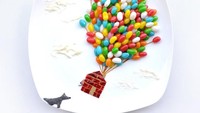 Permen warna-warni ini ditata hingga tampilannya seperti balon terbang yang membawa rumah yang digambar dari saus tomat. Foto: Instagram @redhongyi