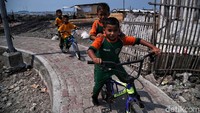 Sejumlah anak bermain sepeda di sekitar lokasi proyek tanggul laut.