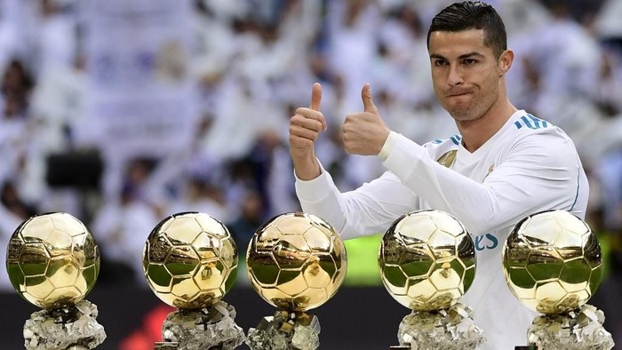 Real Madrids Portuguese forward Cristiano Ronaldo poses with his five Ballon dOr trophies ahead of the Spanish league football match between Real Madrid and Sevilla at the Santiago Bernabeu Stadium in Madrid on December 9, 2017. (Photo by PIERRE-PHILIPPE MARCOU / AFP)