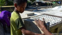 Terlihat juga anak-anak sepulang sekolah ikut membantu proses pendistribusian batako.