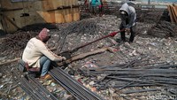 Para pekerja membuat rangka besi untuk pembangunan tanggul laut.