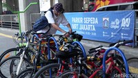 Seorang penumpang tengah berusaha mengeluarkan sepedanya.