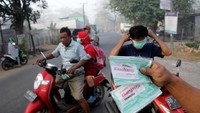 Pengendara memakai masker yang dibagikan oleh relawan secara gratis di Kecamatan Manggala, Makassar, Sulawesi Selatan, Rabu (18/9/2019). ANTARA FOTO/Arnas Padda.