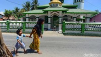 Warga melintas di depan Masjid Annur yang ada di Pulau Rote, Nusa Tenggara Timur.