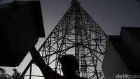 Pekerja melakukan pengecekan tower milik TBIG.