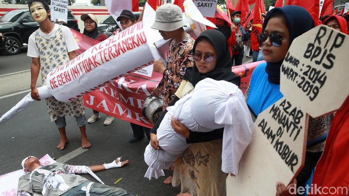 Massa dari berbagai organisasi gelar aksi demo di depan gedung Kementerian Kesehatan. Aksi teatrikal turut ramaikan demo soal kenaikan iuran BPJS Kesehatan itu. (Foto: Ari Saputra) Massa dari berbagai organisasi gelar aksi demo di depan gedung Kementerian Kesehatan. Aksi teatrikal turut ramaikan demo soal kenaikan iuran BPJS Kesehatan itu. (Foto: Ari Saputra)