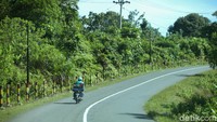 Seorang pengendara motor nampak melintas di jalan yang berada di kawasan Pulau Simeulue, Aceh.
