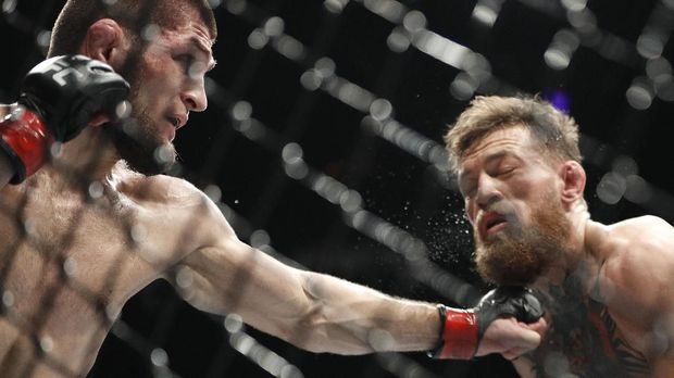 FILE - In this Oct. 6, 2018, file photo, Khabib Nurmagomedov, left, punches Conor McGregor during a lightweight title mixed martial arts bout at UFC 229 in Las Vegas. Nurmagomedov has not fought in the 11 months since he punctuated his star-making victory over McGregor at UFC 229 in Las Vegas by scaling the fence and jumping into the crowd to fight McGregor’s entourage. (AP Photo/John Locher, File)