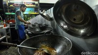 Seorang juru masak tengah sibuk menyiapkan pasanan makanan para pengunjung yang datang ke rumah makan tersebut.