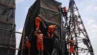 Petugas membongkar terpal yang menutupi bangunan tersebut.