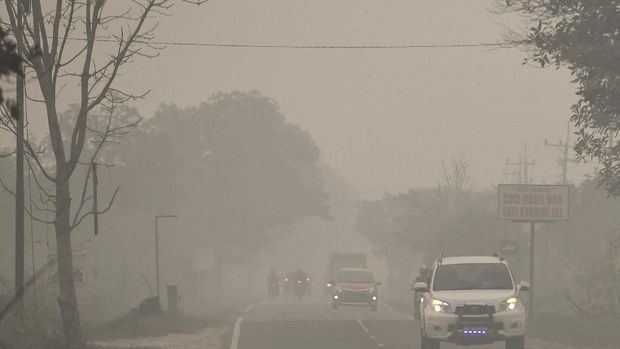 KUALITAS UDARA PALANGKARAYA BERBAHAYA Kendaraan melintas di Jalan Trans Kalimantan yang diselimuti asap di daerah Panarung, Palangka Raya, Kalimantan Tengah, Selasa (17/9/2019). Kabut asap akibat kebakaran hutan dan lahan yang menyelimuti Kota Palangkaraya, Kalimantan Tengah, menyebabkan kualitas udara di kota itu berbahaya untuk kesehatan warga. ANTARA FOTO/Hafidz Mubarak A/ama.