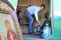 Pria Mengangkut Air Suci yang Hendak Disiram Lewat Udara