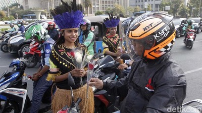 Mahasiswa Papua Bagi-bagi Bunga di Patung Kuda