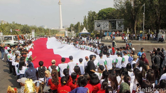 Massa yang tergabung dalam Masyarakat Penegak Demokrasi menggelar aksi di depan Istana Merdeka, Jakarta. Mereka membentangkan bendera merah putih raksasa.