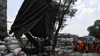 Petugas menarik bangunan pembuatan arang hingga roboh.