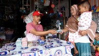 Untuk mencairkan dana bantuan Program Keluarga Harapan, Linda bersama anaknya berjalan kaki menuju ke salah satu toko untuk melakukan transaksi perbankan melalui agen BRILink.