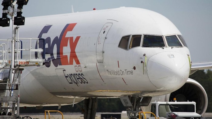 FILE- In this April 18, 2017, file photo, a FedEx cargo plane sits idle during the day at Richmond International Airport in Sandston, Va. FedEx says one of its pilots was detained in China after an item was found in his luggage before he boarded a commercial flight. The company said Thursday, Sept. 19, 2019 the pilot was later released, and it is working with Chinese authorities to understand what happened at the airport in Guangzhou, in southern China.(AP Photo/Steve Helber, File)
