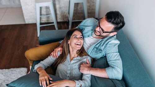 Top view of couple relaxing on sofa.