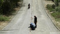 Pekerja tengah memasang papan untuk pengecoran jalan.
