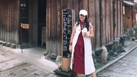 Jalan-jalan di Jepang, Lies terlihat santai berpose di depan coffee shop. Ia juga menggenggam segelas ess kopi di tangannya.  Foto: instagram @lies1801