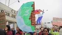 Sejumlah warga di Peru ikut serta dalam aksi peduli iklim. Seorang peserta aksi membawa serta ilustrasi eksploitasi kekayaan sumber daya alam yang berimbas pada perubahan iklim di bumi.Istimewa/Guadalupe Pardo/Reuters.
