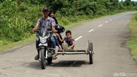 Seorang warga bersama anaknya menggunakan becak untuk melakukan kegiatan sehari-hari.