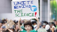 Aksi peduli iklim juga digelar di Jepang. Seorang anak membawa poster bertuliskan United Behind The Science dalam aksi tersebut. Istimewa/Kyodo via AP Photo.