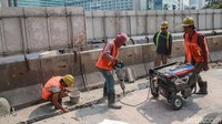 Sejumlah petugas nampak hilir mudik merampungkan proyek pelebaran dan revitalisasi trotoar di kawasan Bundaran HI, Jakarta.