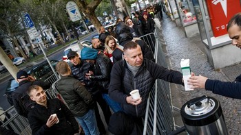 Cuaca dingin tak menyurutkan niat mereka. Menghabiskan waktu, mereka mengobrol sambil minum kopi. Foto: Getty Images