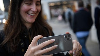 Seorang wanita menjajal iPhone 11 Pro di dalam Apple Store. Foto: Getty Images