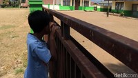 Seorang anak melihat ke dalam halaman SDN Santosa yang menjadi salah satu relokasi para siswa dari SDN Cisabuk untuk kegiatan belajar mengajarnya. 