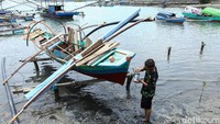 Nelayan memperbaiki kapalnya di pesisir pantai di Simeulue.