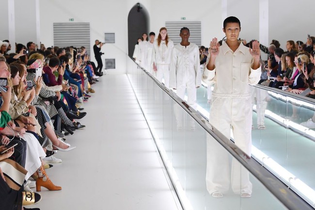 Seperti dilaporkan The Guardian, seorang model yang diketahui bernama YaYa Bones tiba-tiba saja menggelar aksi protes di sela-sela penampilannya memeragakan koleksi spring/summer Gucci 2020. Yaya yang berambut plontos itu mengangkat kedua tangannya yang sudah ditulis sebuah pesan bermakna. Foto: Getty Images