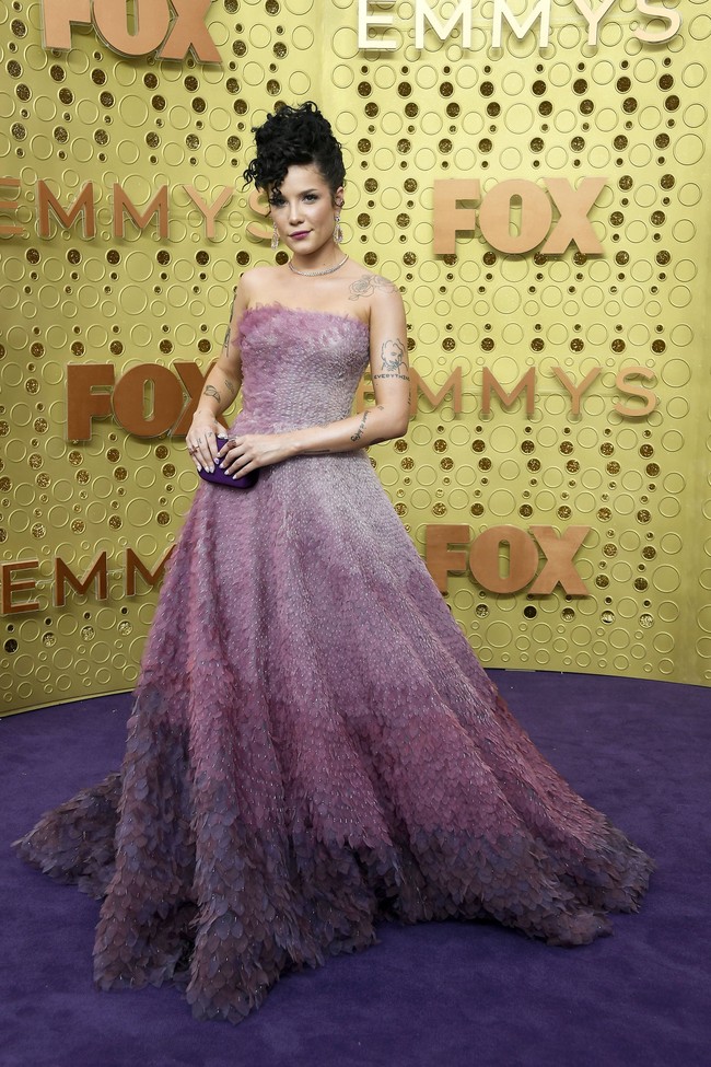 Penyanyi Halsey punya cara tersendiri untuk mencari atensi di penampilan perdananya di Emmy Awards 2019. Sembari tampil anggun dengan gaun strapless berwarna ungu yang bergradasi, ia memamerkan koleksi tato yang menghiasi sekujur tangannya. Sebuah kombinasi unik antara elegansi dan kegaharan. (Foto: Getty Images)