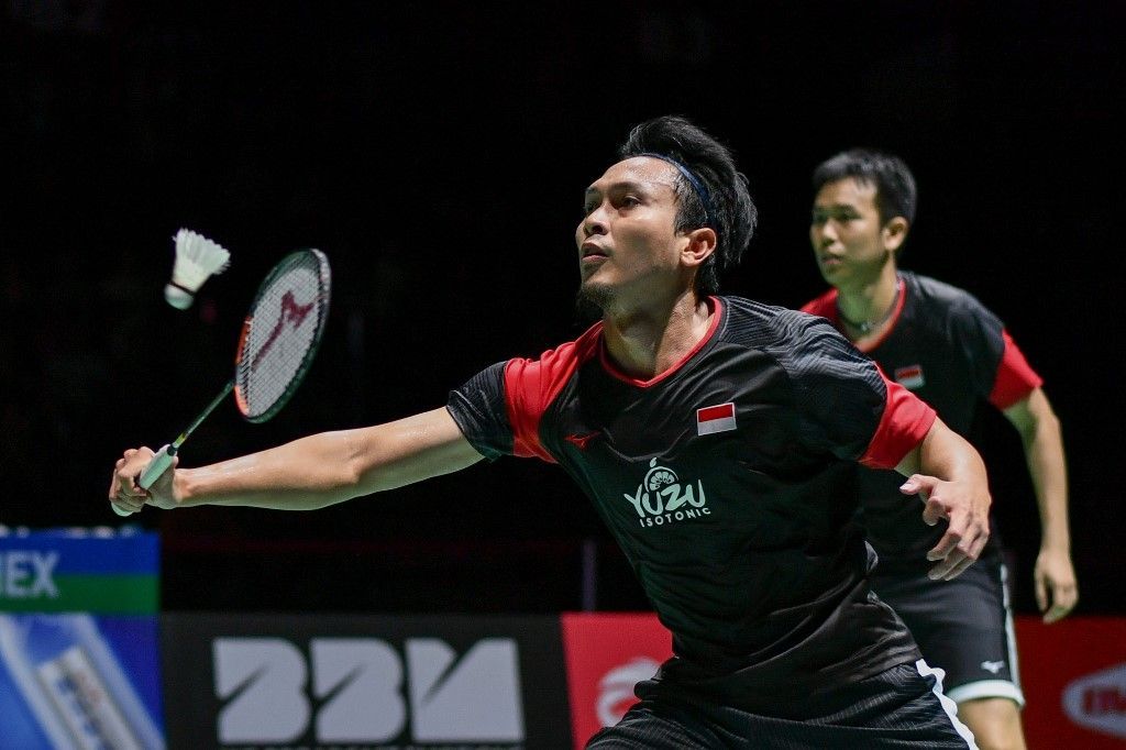 Indonesia's Mohammad Ahsan (L), next to Indonesia's Hendra Setiawan, returns a shuttlecock to Japan's Yugo Kobayashi and Japan's Takuro Hoki during of their men's doubles final game at the BWF Badminton World Championships at the St Jakobshalle in Basel on August 25, 2019. (Photo by FABRICE COFFRINI / AFP)
