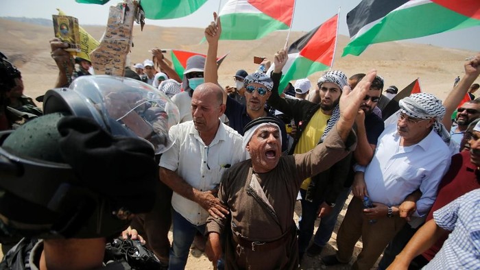 Palestinians shout in front of Israeli troops during a protest against Jewish settlements, in  Al-Sawaherh in the Israeli-occupied West Bank September 20, 2019. REUTERS/Mussa Qawasma