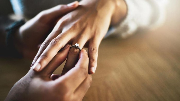 Melamar kekasih Cropped shot of a man putting an engagement ring onto his girlfriends finger
