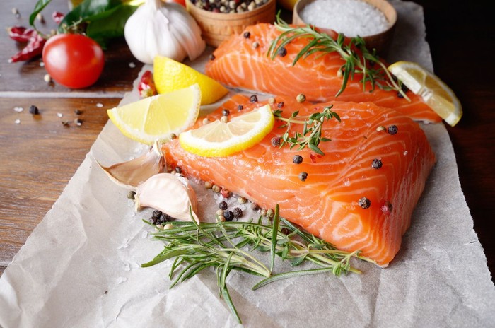 portions of fresh salmon fillet with aromatic herbs, spices and vegetables