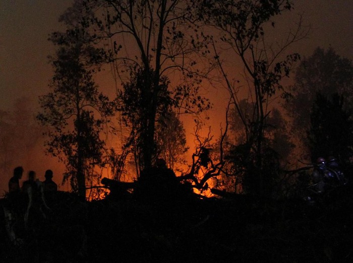 Satgas Karhutla Riau terus berjibaku memadamkan kebakaran lahan di Desa Rimbo Panjang, Kabupaten Kampar, Riau, Minggu (22/9/2019). Kebakaran lahan yang meluas dan mulai mengancam permukiman penduduk di kawasan tersebut membuat petugas terus melakukan upaya pemadaman hingga malam hari. ANTARA FOTO/Rony Muharrman/foc.