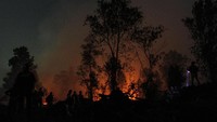 Kebakaran lahan yang meluas dan mulai mengancam permukiman penduduk di kawasan tersebut membuat petugas terus melakukan upaya pemadaman hingga malam hari. 