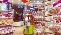 Ini gaya modis Gebby Vesta saat berpose di dalam store sambil memakan es krim berwarna kuning yang menyegarkan. Foto: Instagram @gebby.vesta_