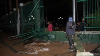 Petugas memperbaiki pagar gedung DPR yang rusak.