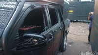Kaca mobil sebelah kiri dipecahkan. Ban depan sebelah kanan pun dikempeskan (Foto: Mochammad Zhacky/detikcom)