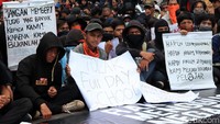 Massa menggelar aksi sambil membawa poster dan spanduk tuntutan.