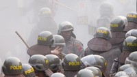 Para polisi mengenakan pakaian pelindung yang lengkap.